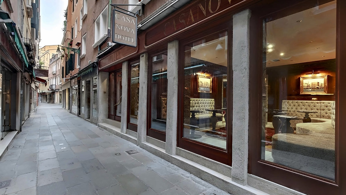 Hotel ground floor with large windows on a quiet stone-paved calle