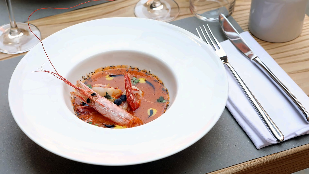 Whole prawn in a tomato fish broth served in a white bowl