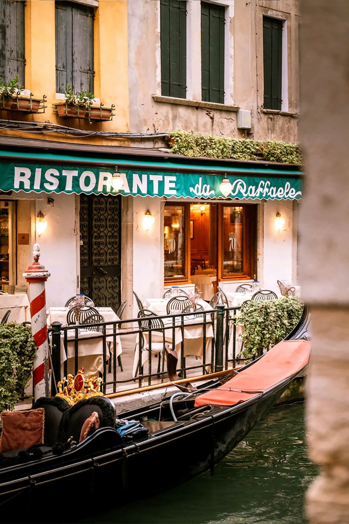 Canal-side terrace with a gondola moored in front of the restaurant