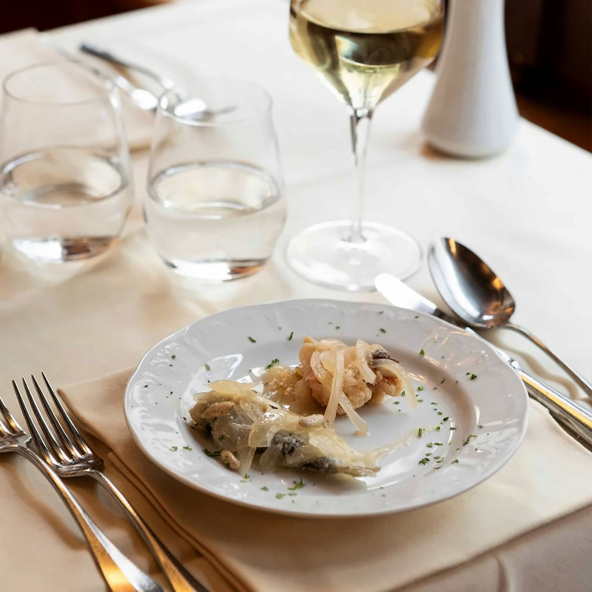 Fish with sweet-and-sour onions and a glass of white wine