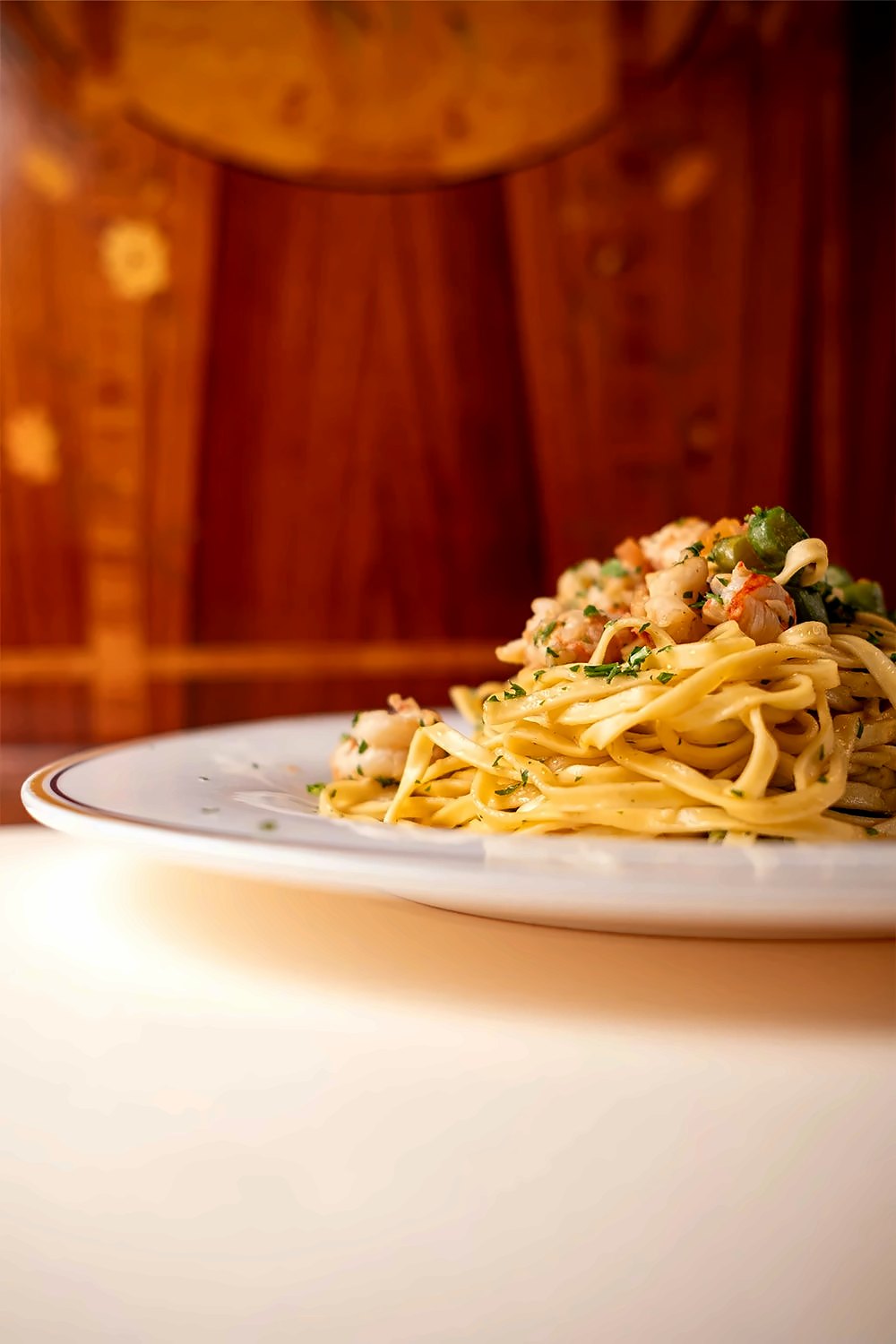 Fresh tagliolini with seafood on a gold-rimmed plate