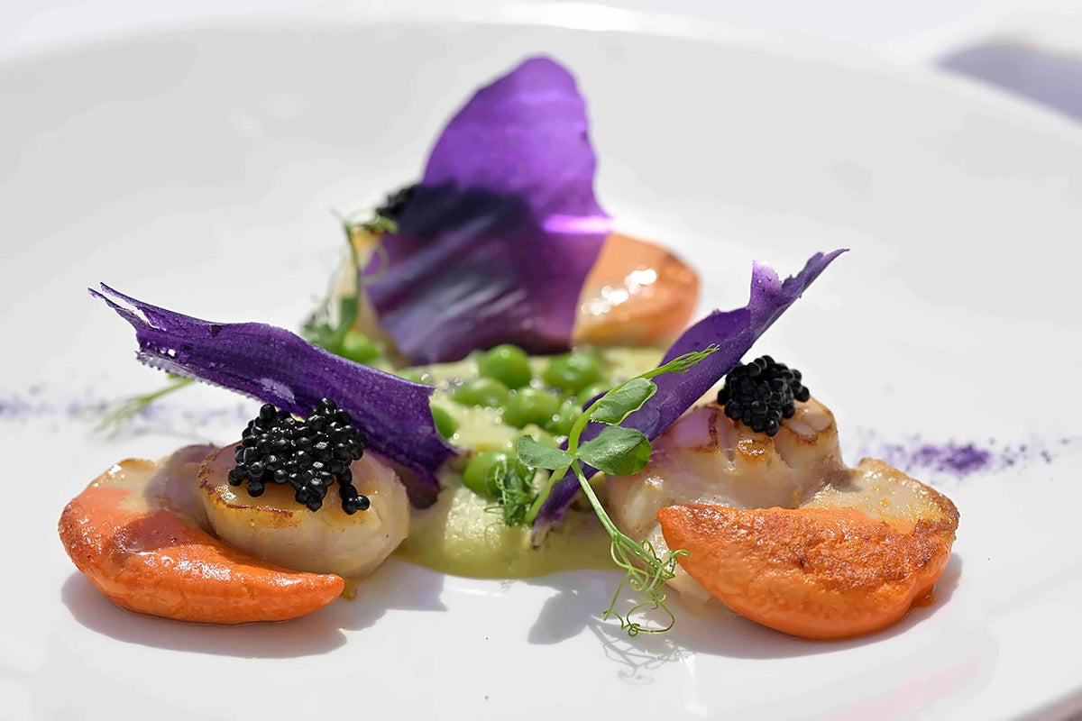 Plated seafood dish with caviar, peas and purple potato crisps at Lineadombra