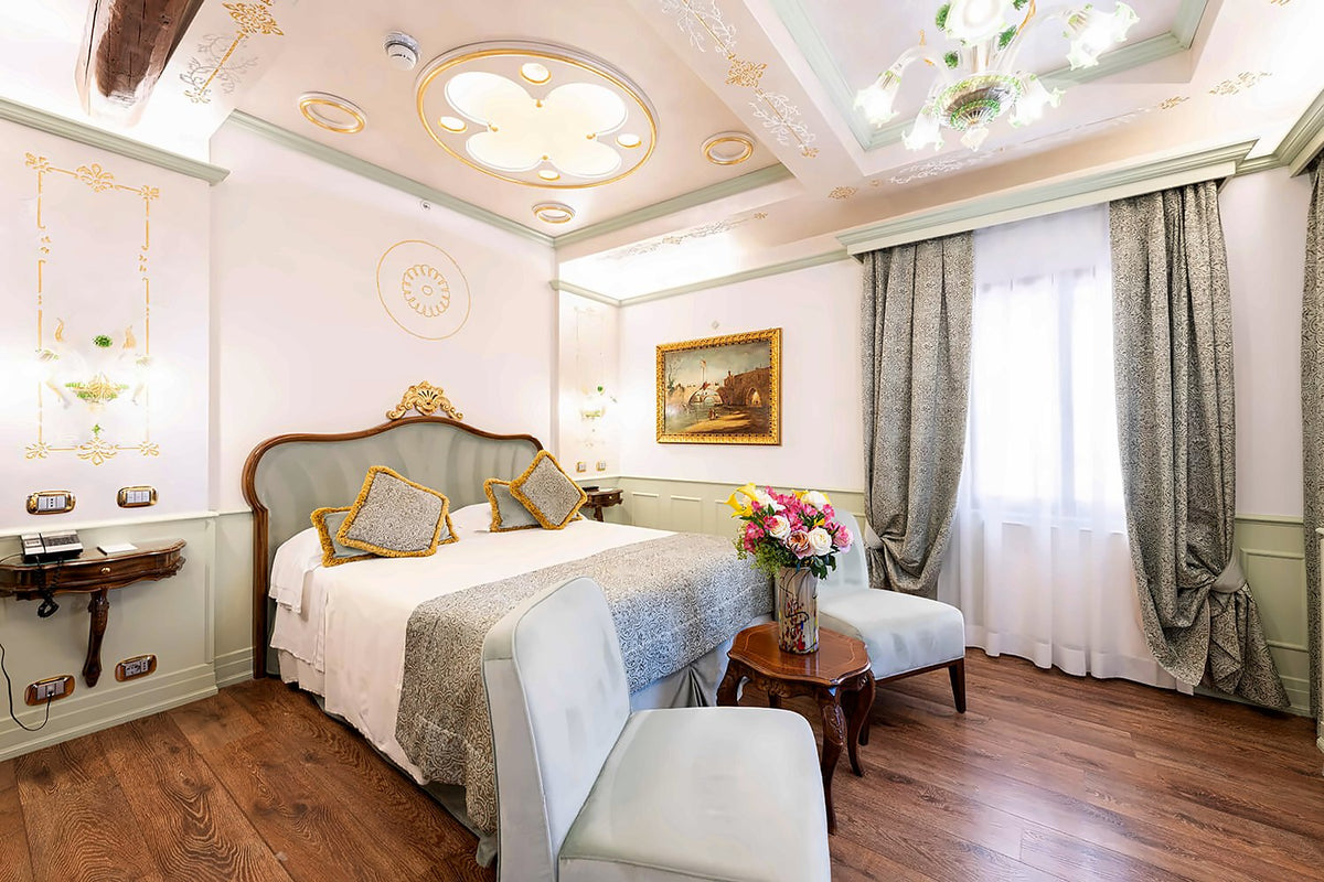 Venetian-style room with stuccoed ceiling, upholstered headboard and wood floor