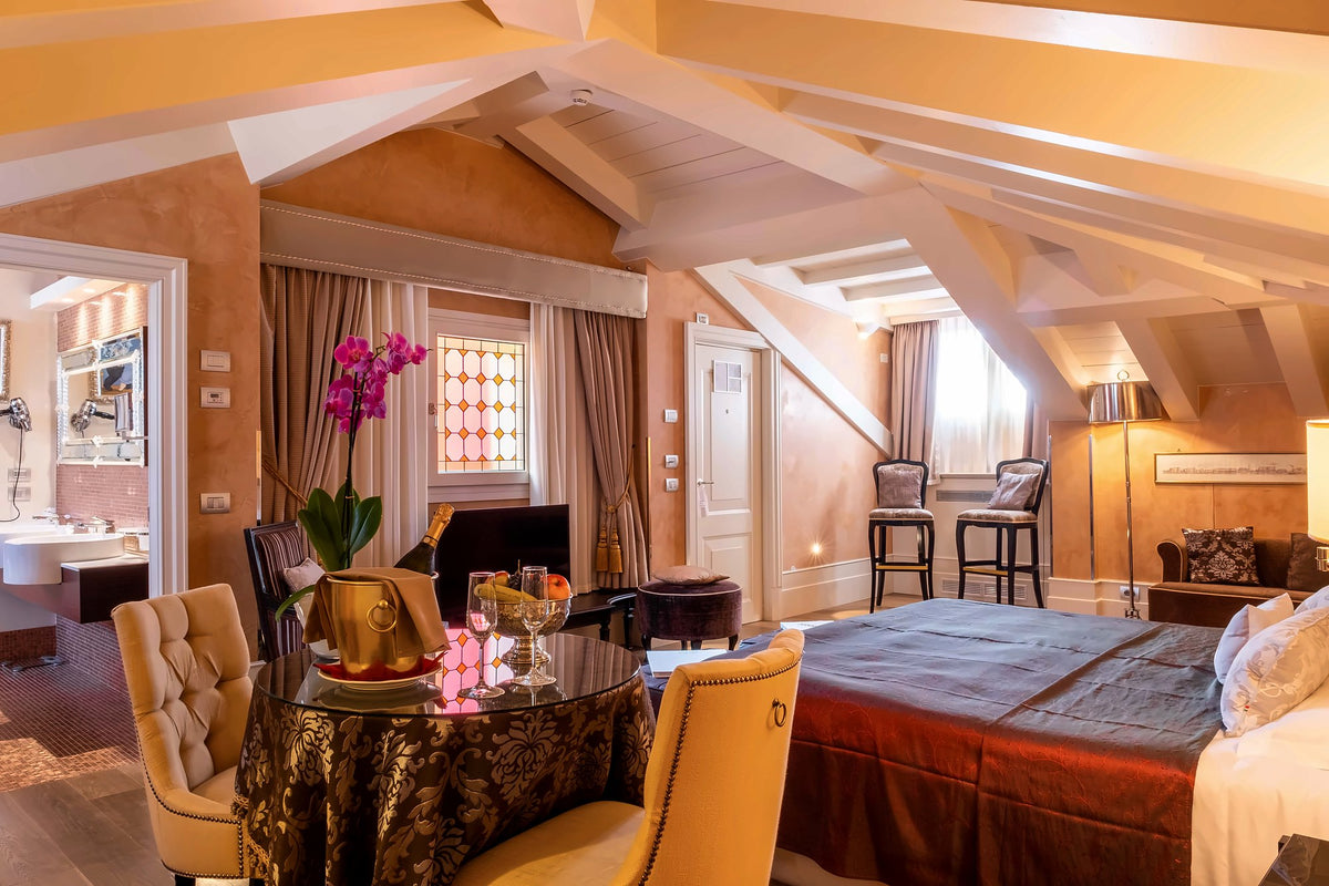 Attic junior suite with exposed beams, orchids and a table set with champagne