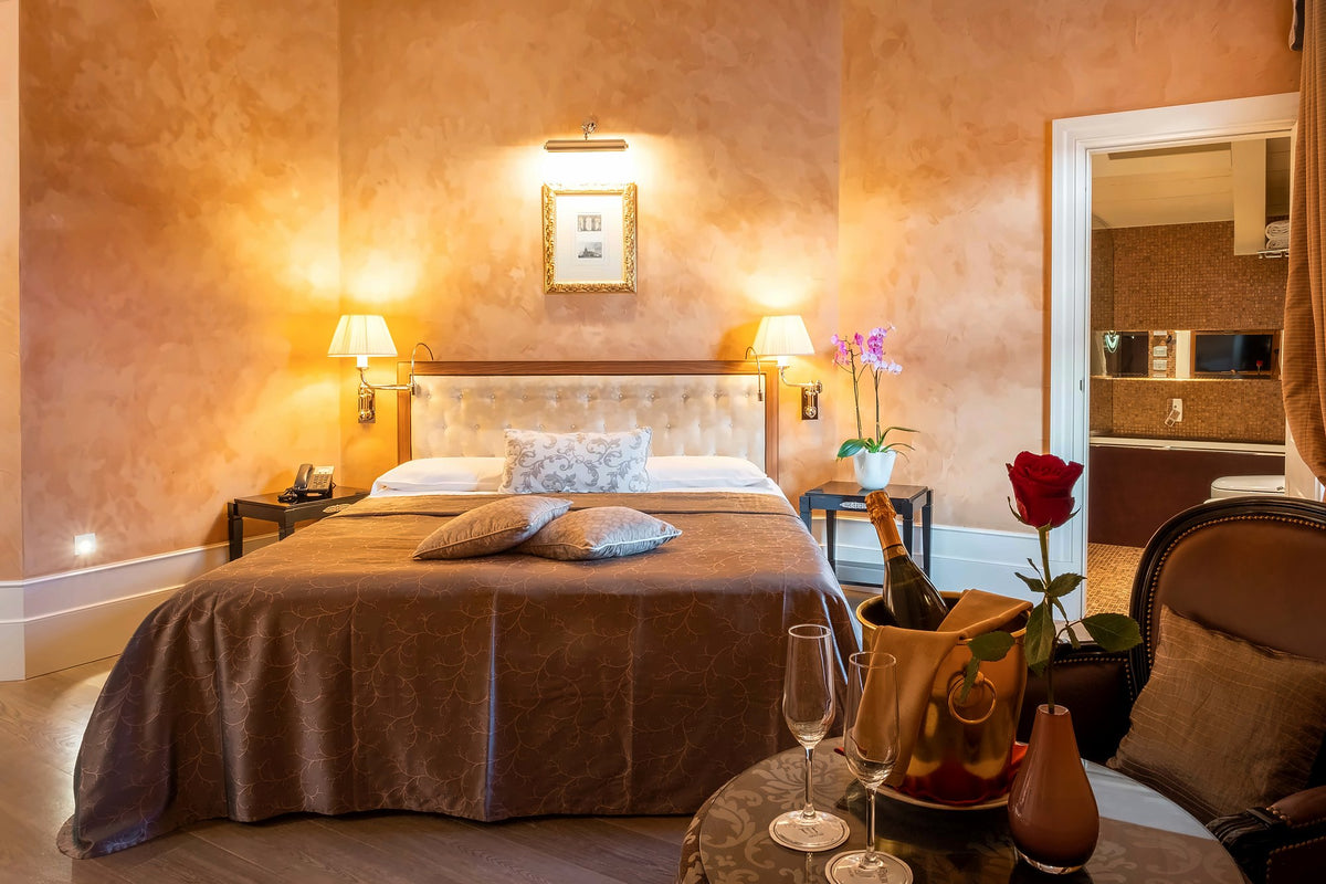 Warm-toned double room with bedside lamps and champagne with a red rose