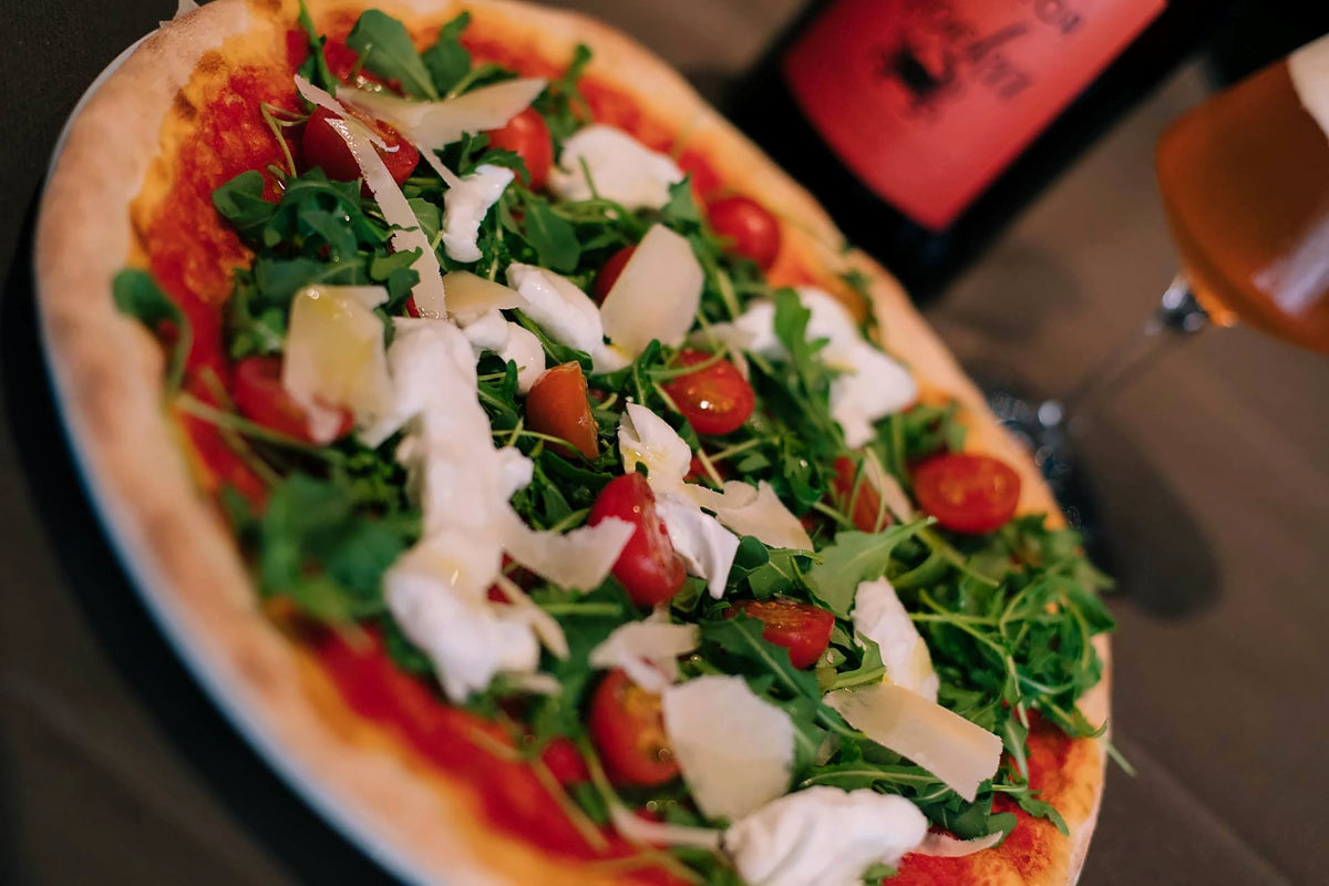 Pizza with rocket, cherry tomatoes and Parmesan shavings at Muro Frari