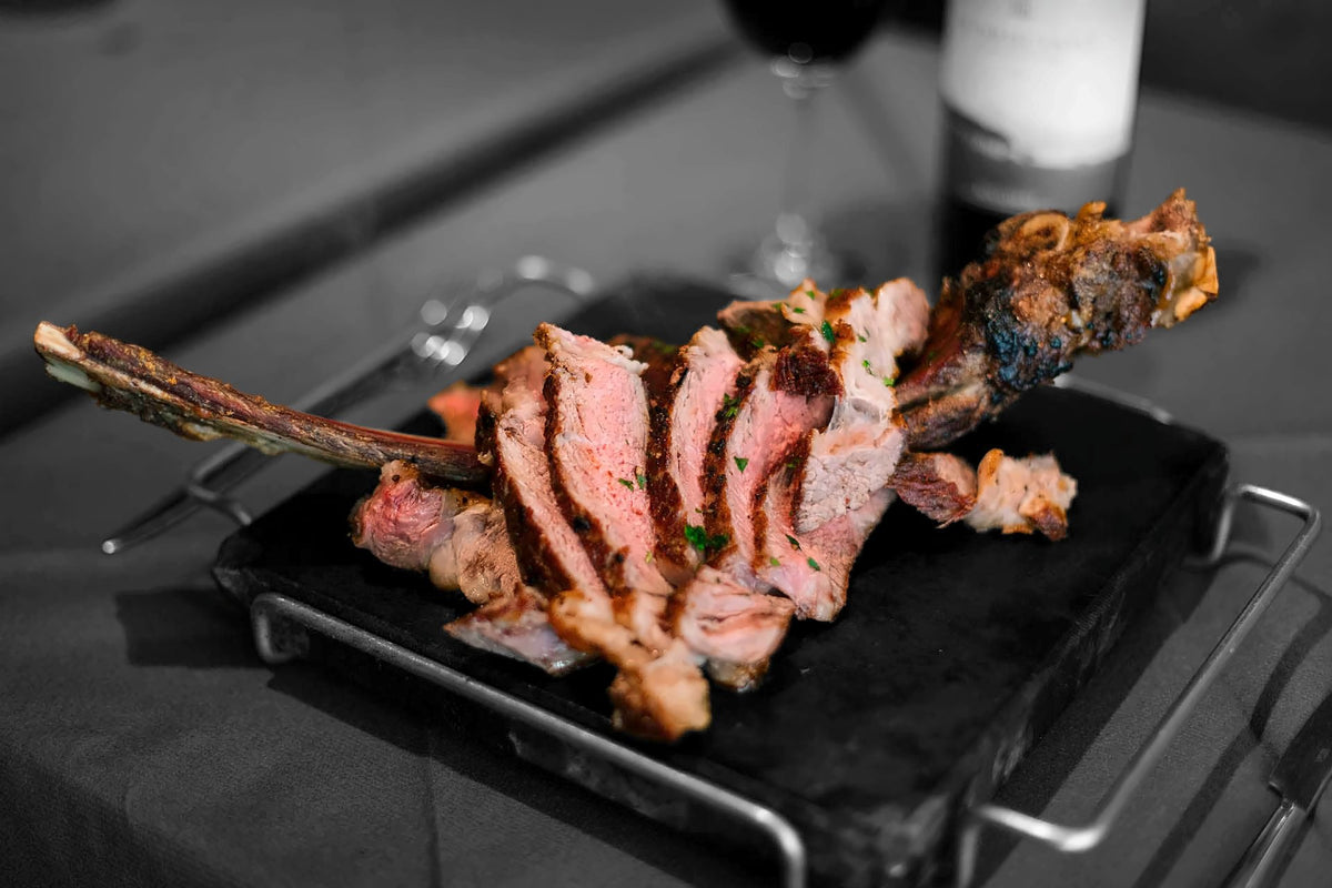 Sliced grilled tomahawk steak on a hot stone at Muro San Stae