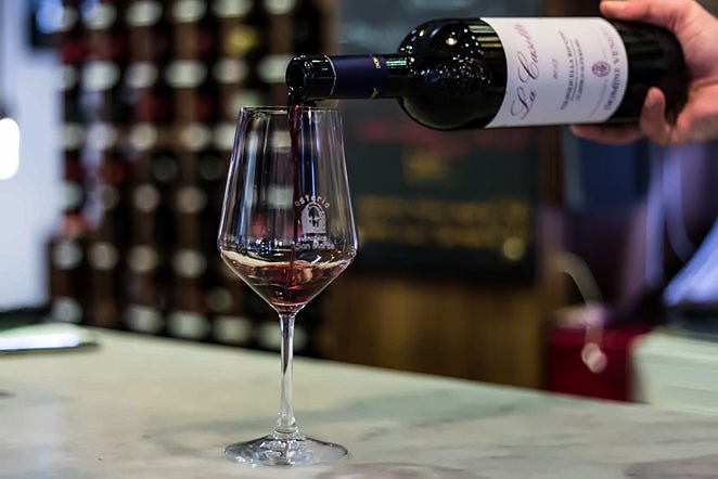 Red wine poured into a glass on the counter at Osteria Enoteca San Marco