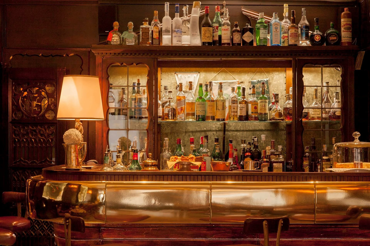 Wood-panelled bar with a wall of bottles and a gleaming brass counter