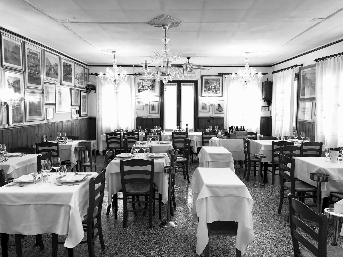 Black-and-white view of the dining room at Trattoria al Gatto Nero, Burano